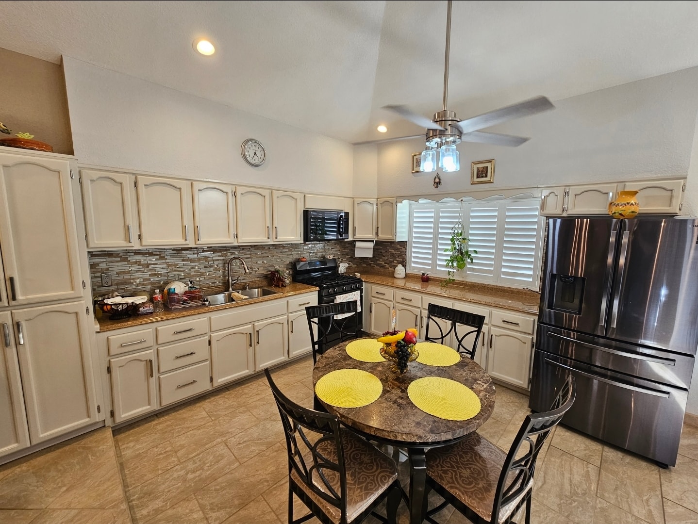 Cream refinished kitchen cabinets with plantation shutters and dining area