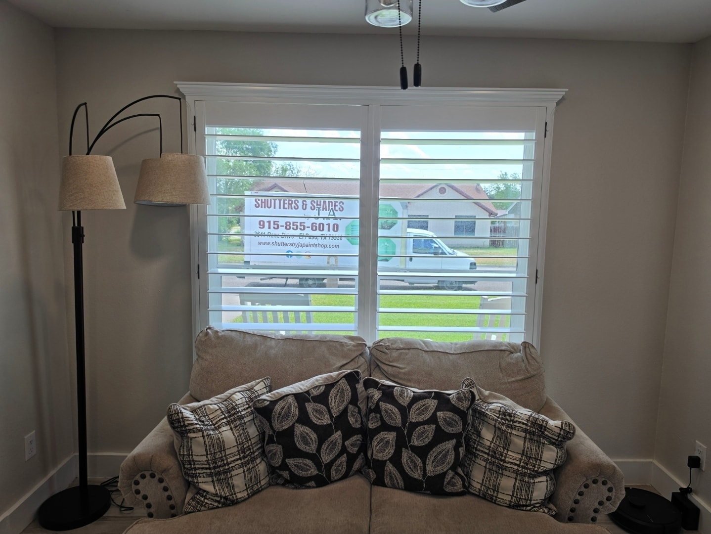 Plantation shutters behind a living room sofa