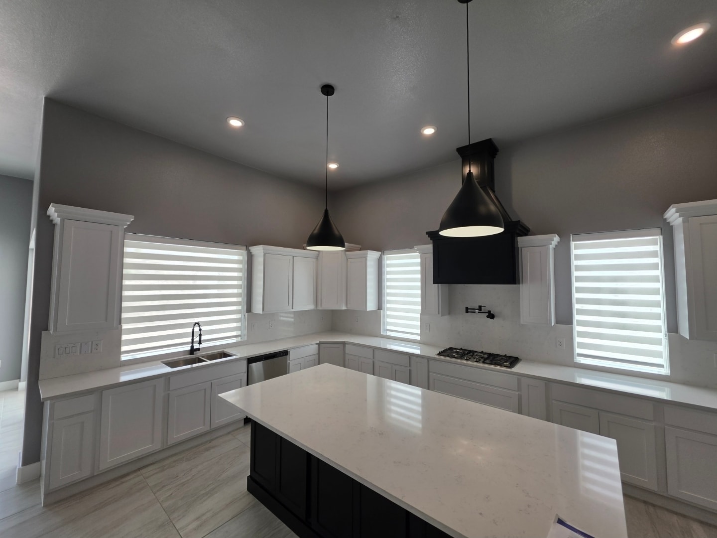 White zebra shades in a modern kitchen with white cabinets